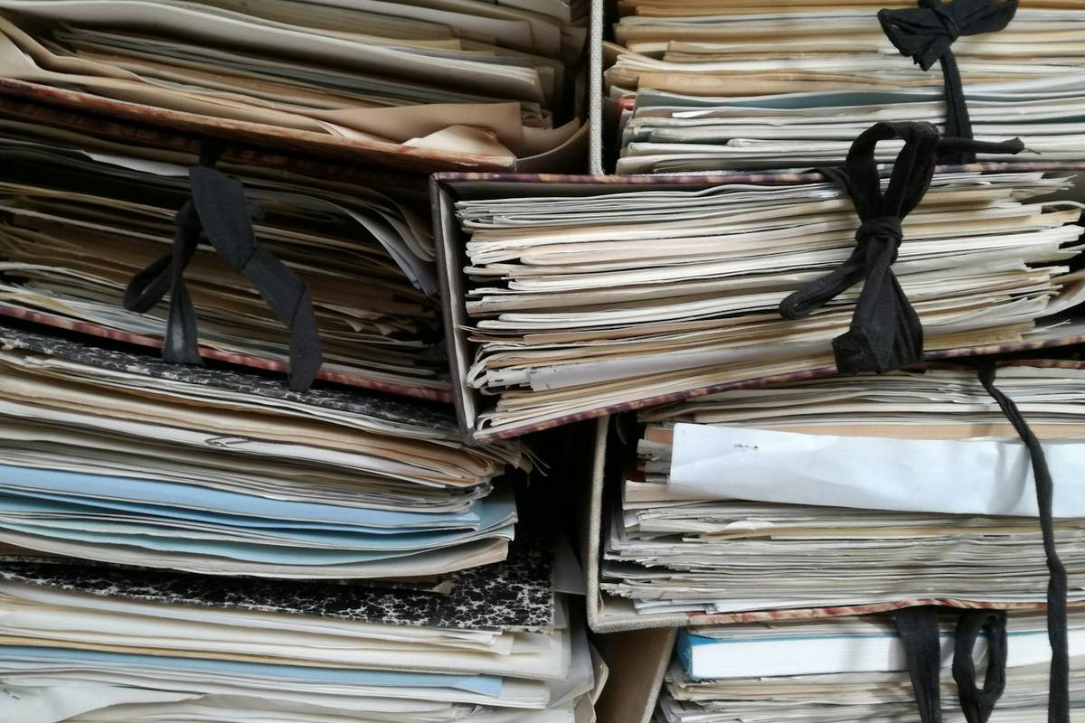 Gebündelte alte Akten und Papiermappen mit Stoffbändern, übereinander gestapelt