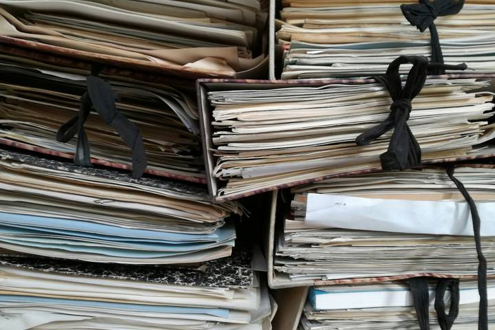 Gebündelte alte Akten und Papiermappen mit Stoffbändern, übereinander gestapelt